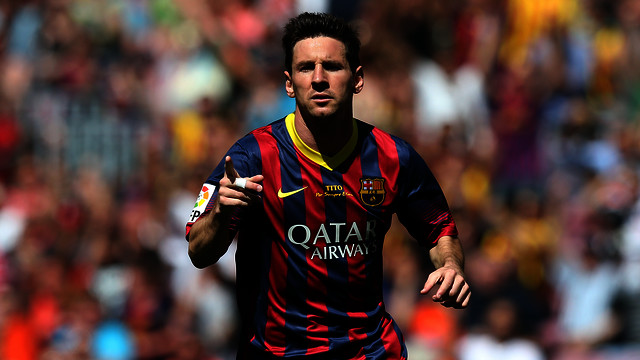 Leo Messi, de cara, señala a su asistente con el brazo derecho