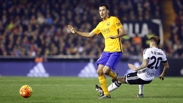 FC Barcelona midfielder Sergio Busquets steps over Valencia midfielder Rodrigo De Paul. / MIGUEL RUIZ